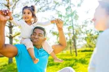 Father with young daughter on shoulders